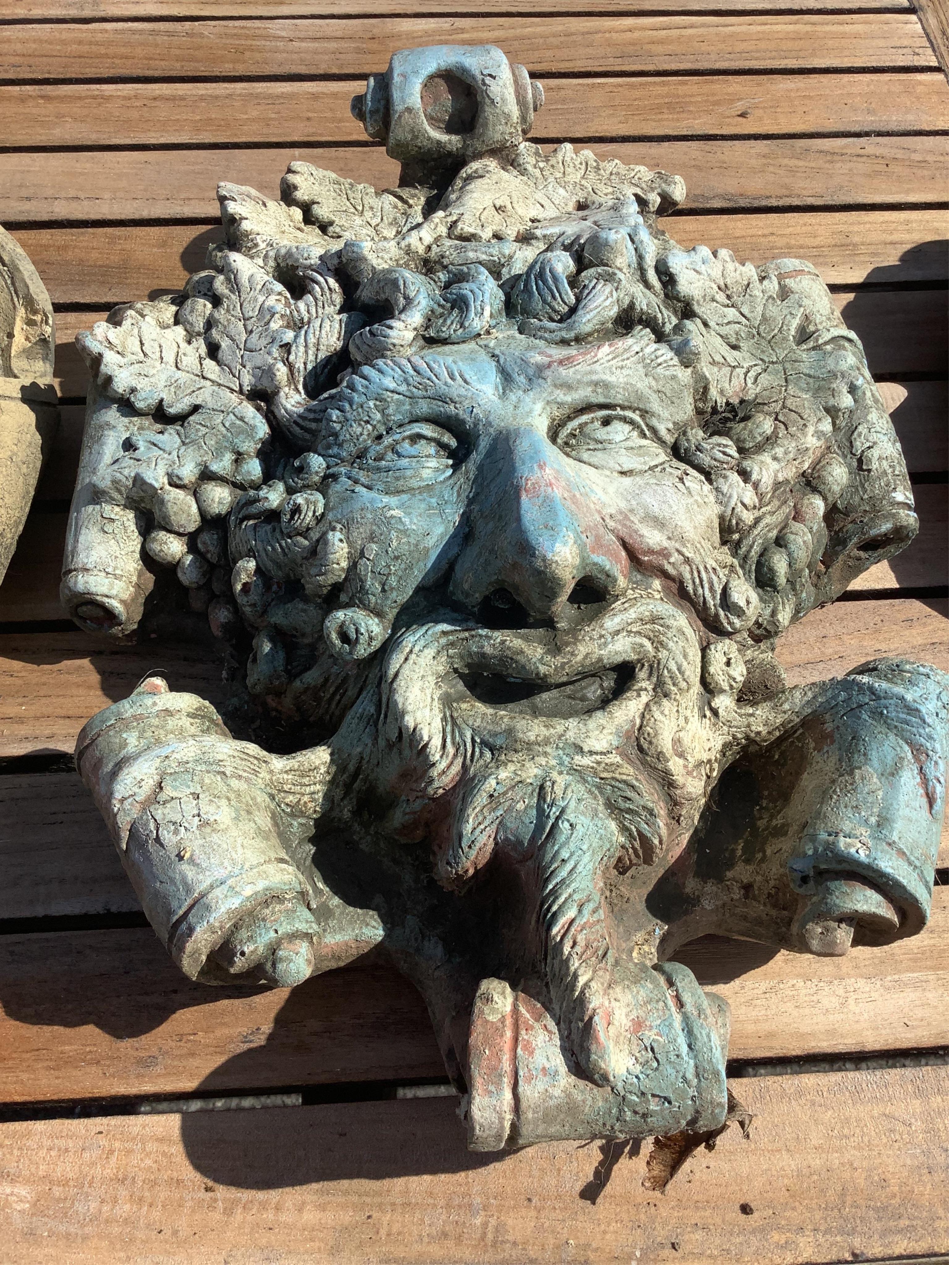Three cast stone and terracotta garden wall mask appliqués, largest height 42cm